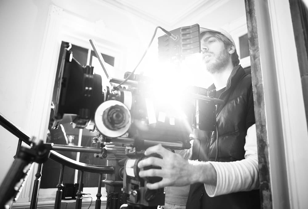 A man holding a camera in front of a building.