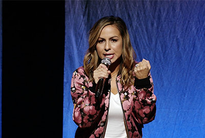 A woman is holding a microphone and singing.