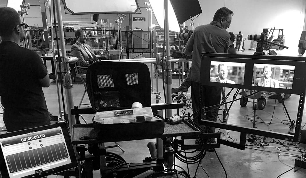 A black and white photo of some people in the process of filming.